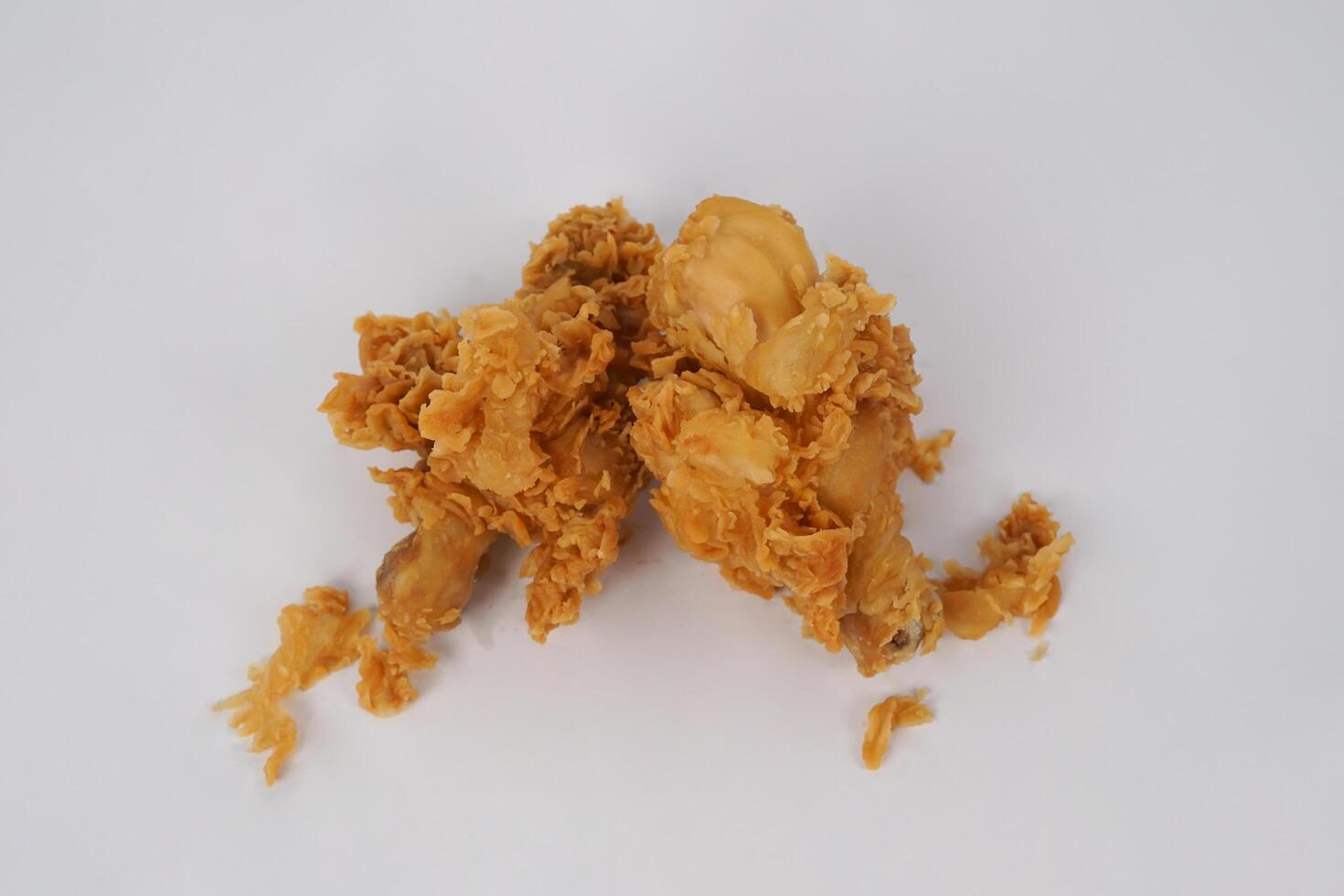 Golden brown fried chicken on white background. Fried chicken isolated over white. Fried chicken isolated on white background. Crispy fried chicken pieces in mid-air with crumbs scattering isolated photo