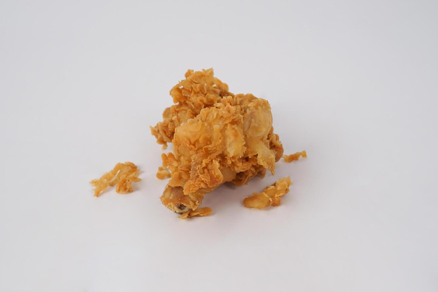 Golden brown fried chicken on white background. Fried chicken isolated over white. Fried chicken isolated on white background. Crispy fried chicken pieces in mid-air with crumbs scattering isolated photo