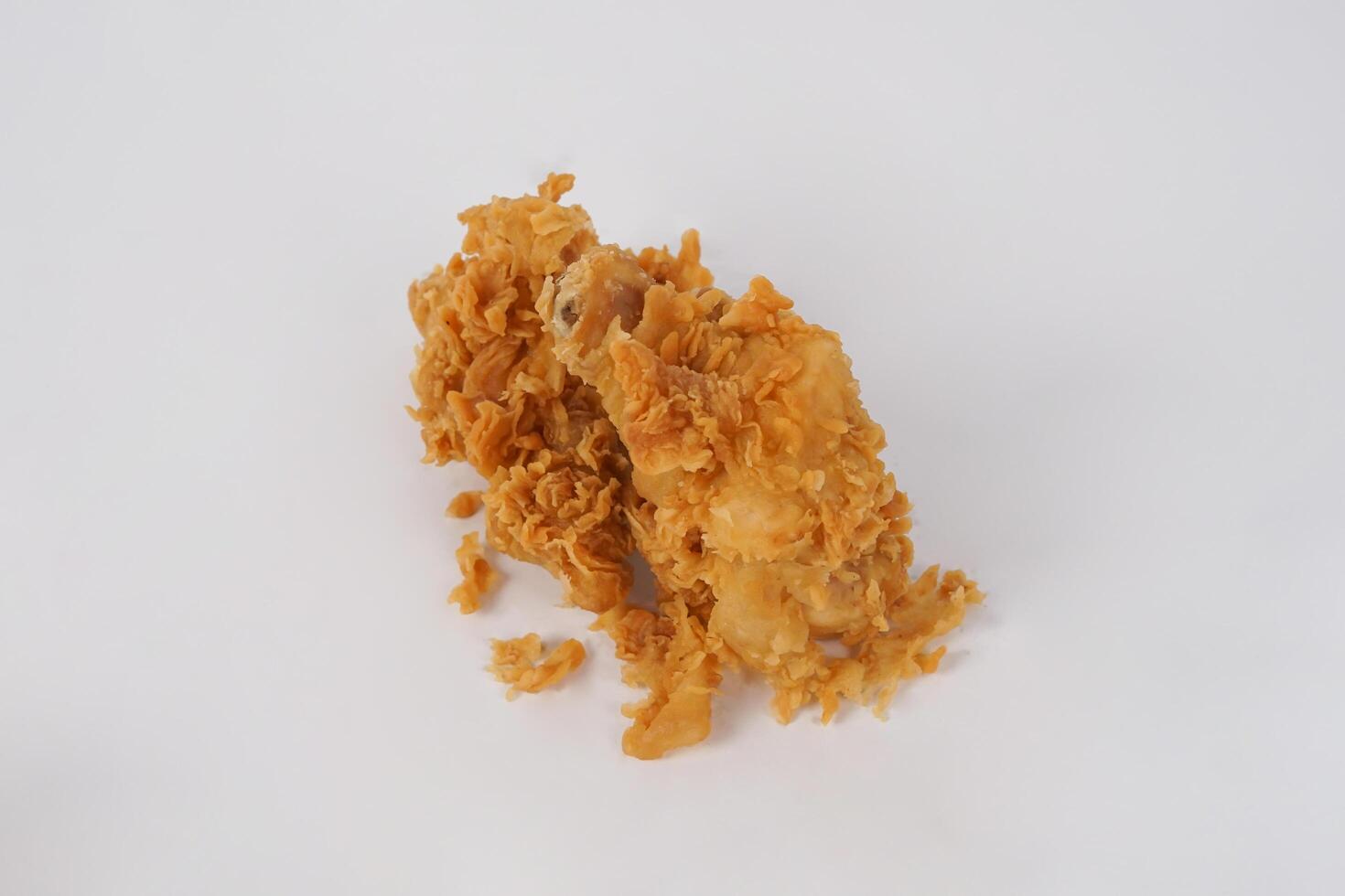 Golden brown fried chicken on white background. Fried chicken isolated over white. Fried chicken isolated on white background. Crispy fried chicken pieces in mid-air with crumbs scattering isolated photo