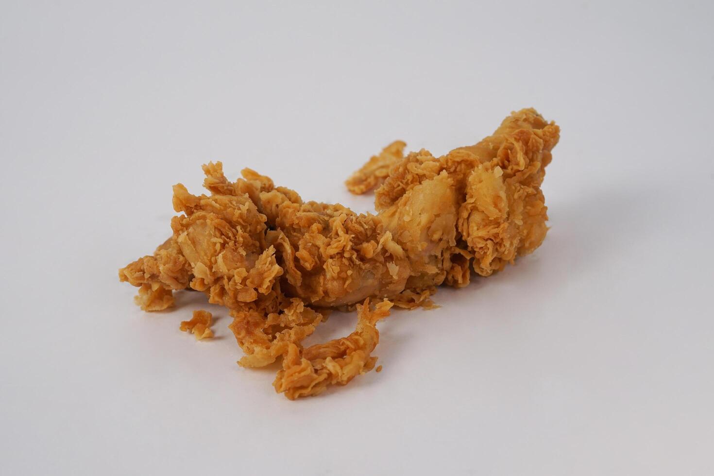 Golden brown fried chicken on white background. Fried chicken isolated over white. Fried chicken isolated on white background. Crispy fried chicken pieces in mid-air with crumbs scattering isolated photo