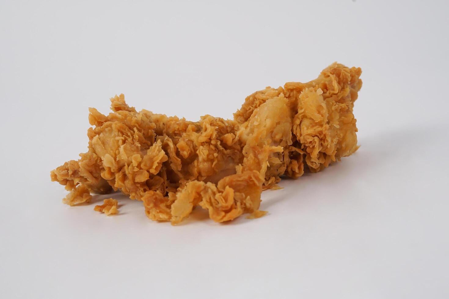 Golden brown fried chicken on white background. Fried chicken isolated over white. Fried chicken isolated on white background. Crispy fried chicken pieces in mid-air with crumbs scattering isolated photo