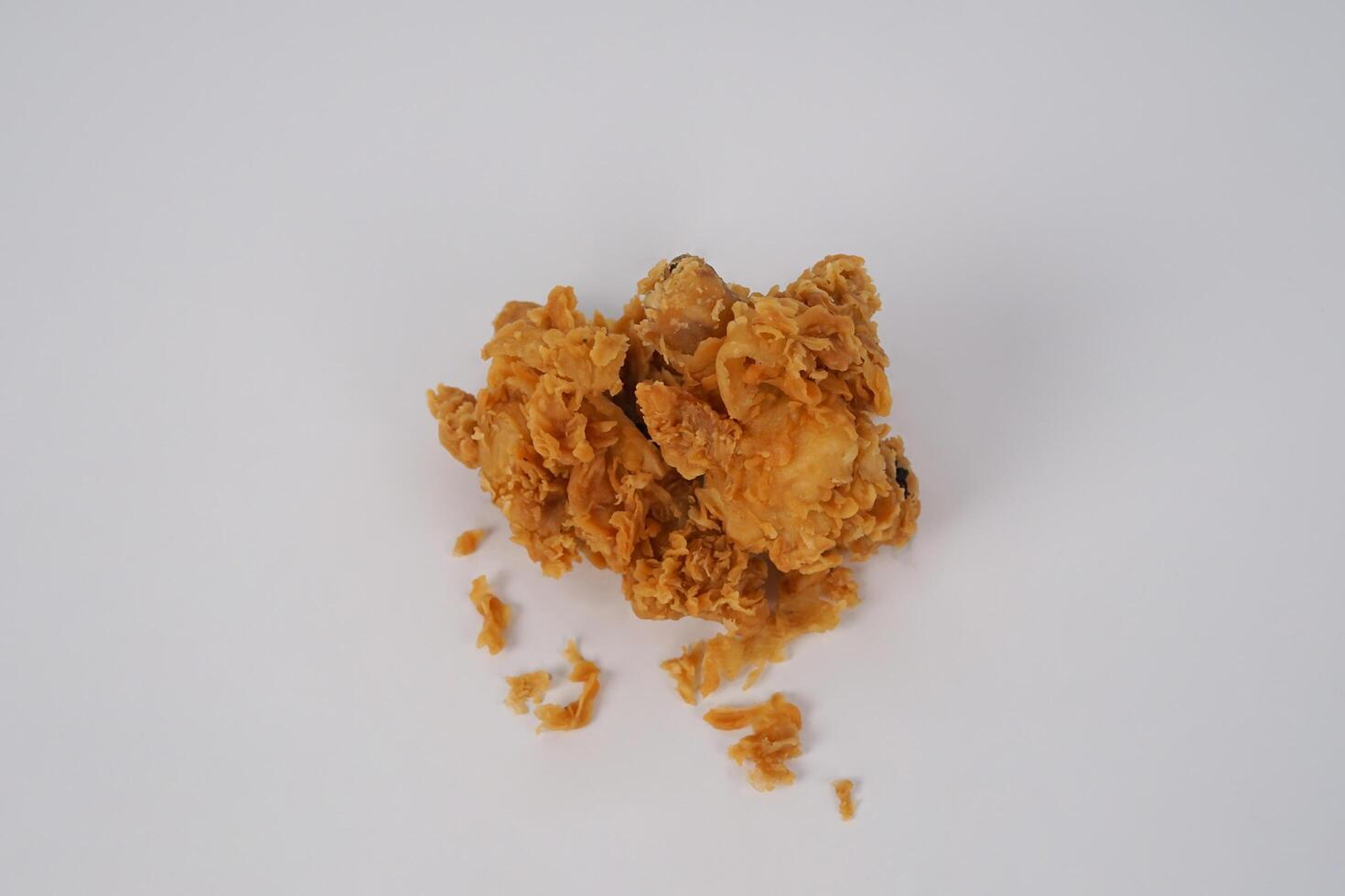 Golden brown fried chicken on white background. Fried chicken isolated over white. Fried chicken isolated on white background. Crispy fried chicken pieces in mid-air with crumbs scattering isolated photo