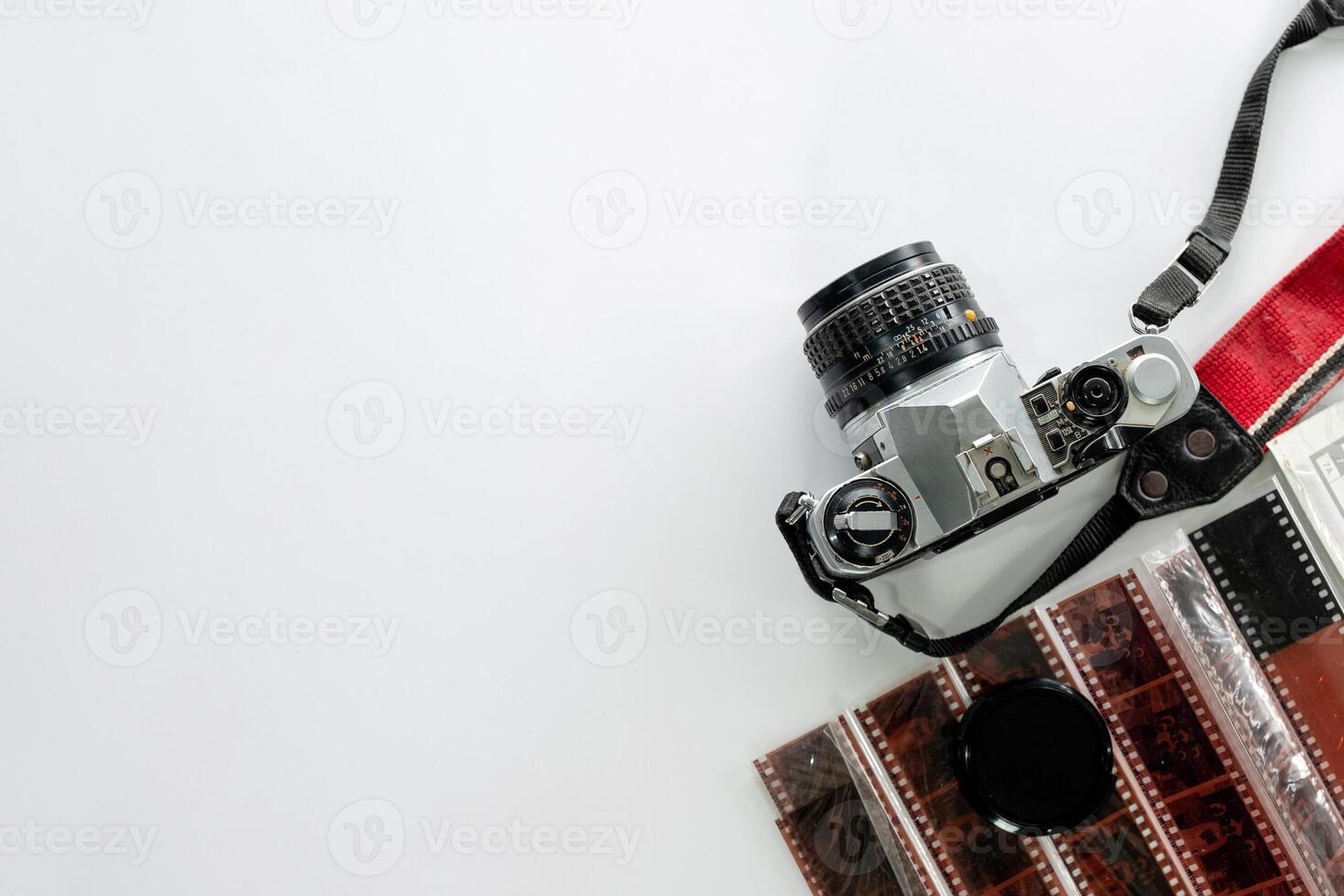 Retro film camera with filmstrip on white background photo