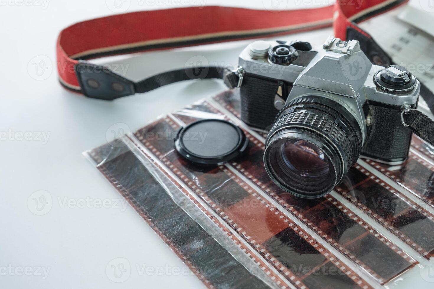 Retro camera with red strap on film negative roll photo
