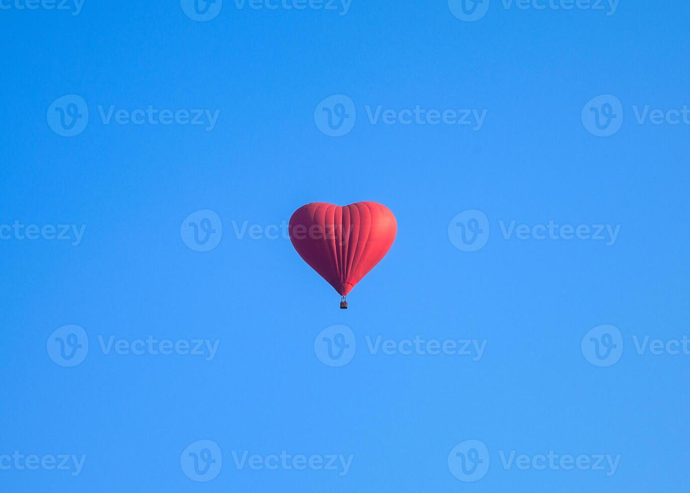 Colorful hot air heart shape balloons flying in blue sky photo
