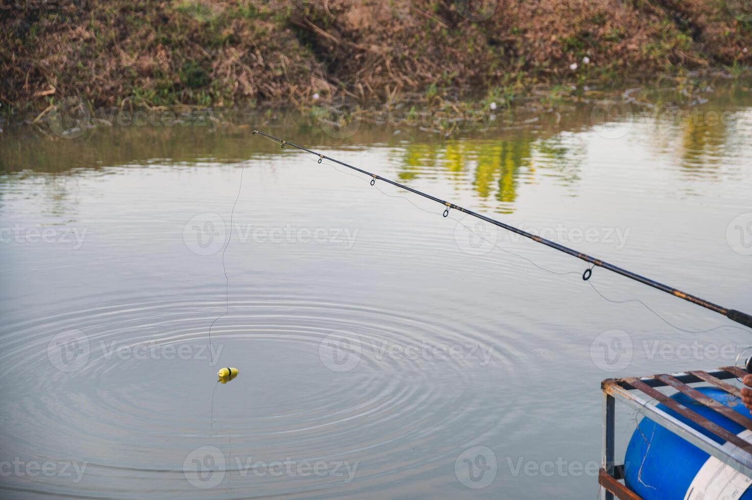 Fisherman with fishing rod and bait in swamp photo