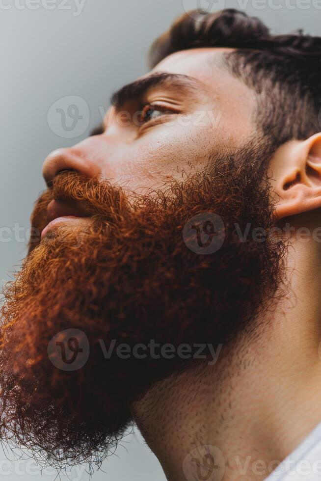 Muslim Man With a Red Beard in Natural Light on Gray Backdrop photo