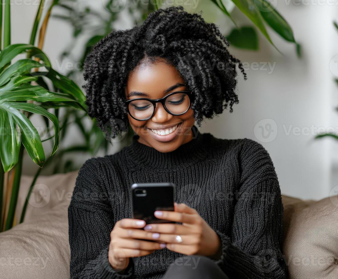 Happy young woman relaxing on a couch while looking at her phone photo