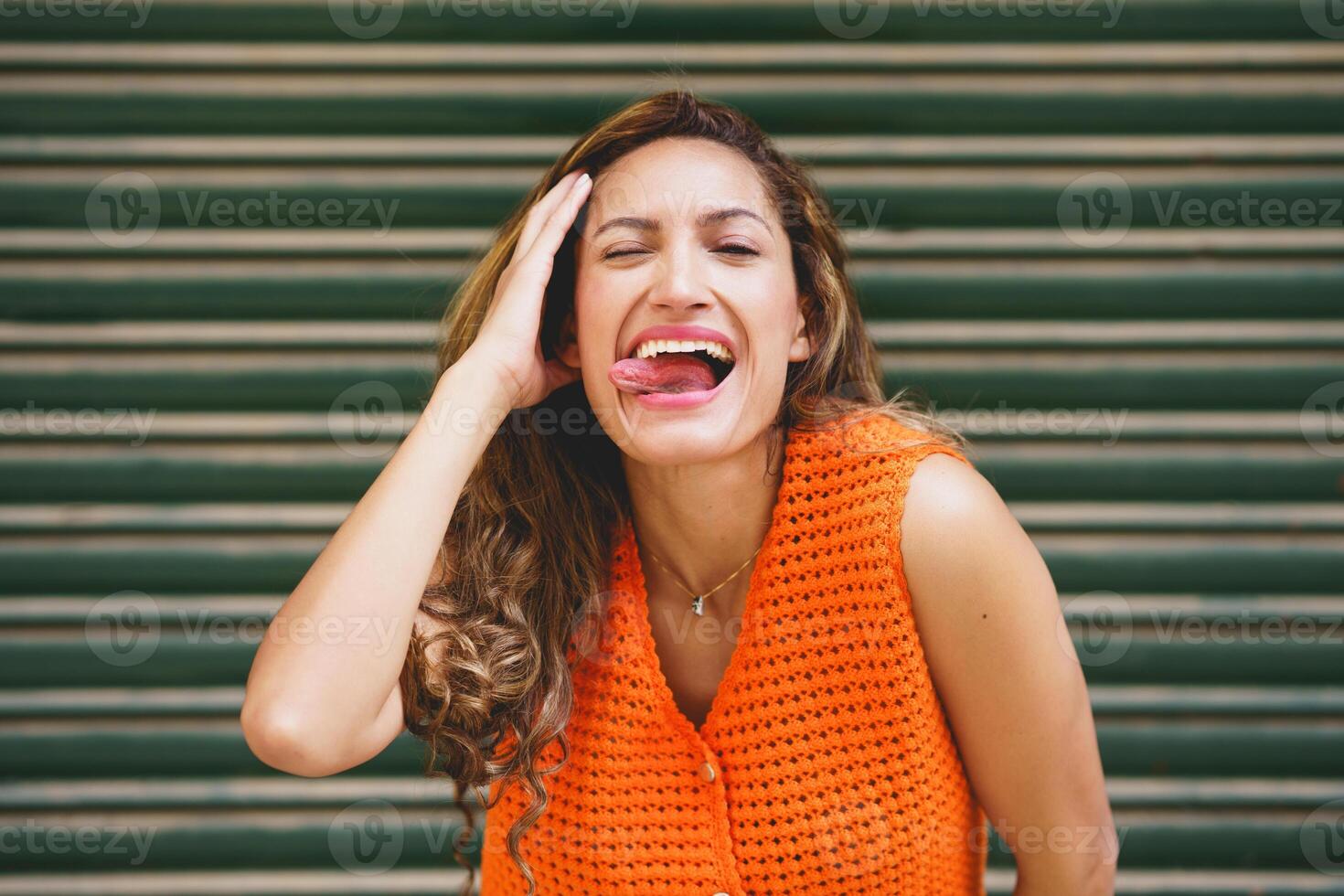 Woman flirting sticking the tongue out smiling at camera photo