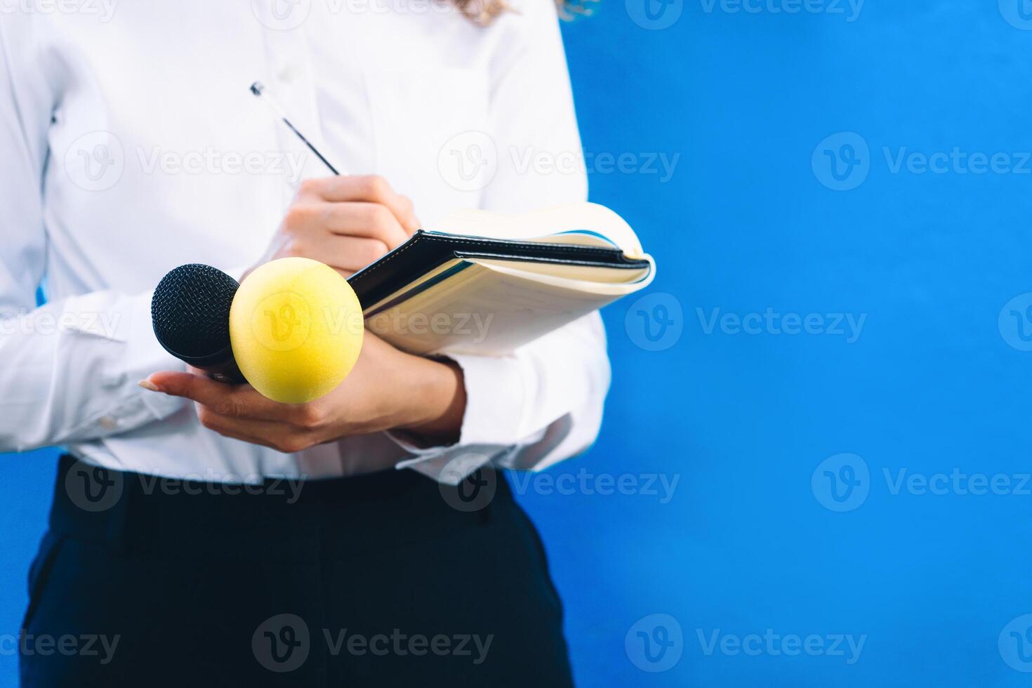 reporter with a notebook, a pen and two microphones asking questions. journalist concept. photo