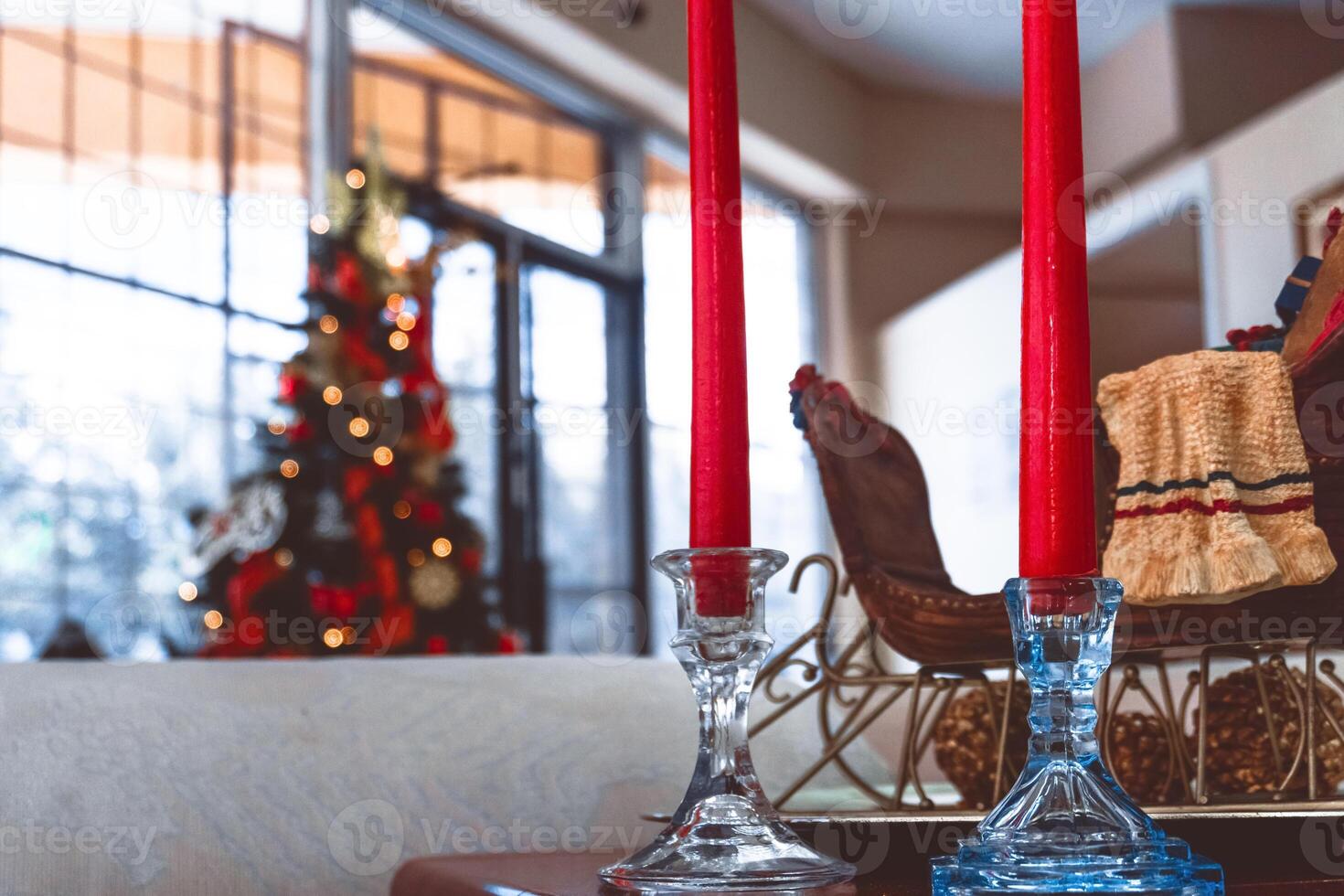 A shot of two candles on the background of a Christmas tree with bright lights photo