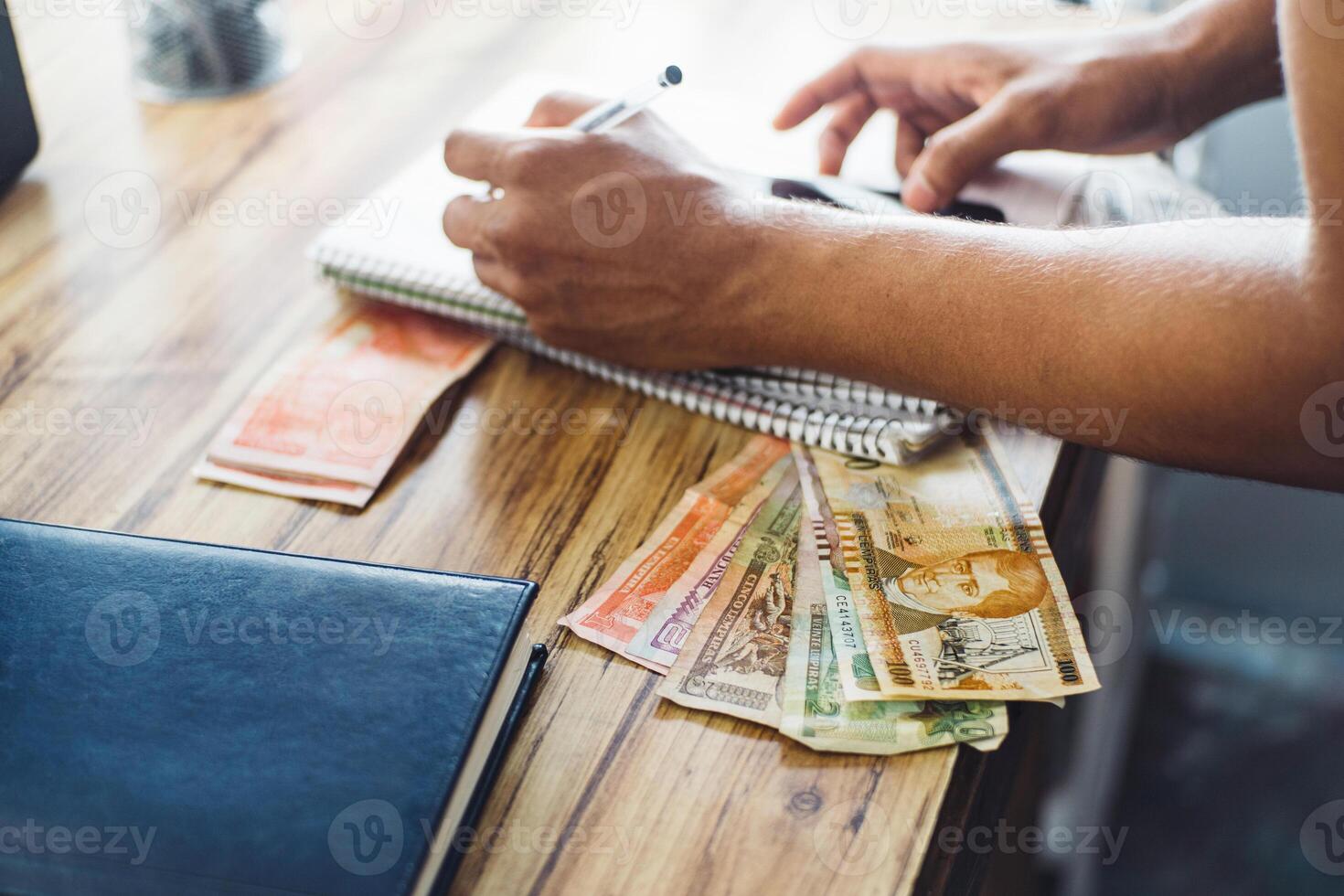 Unfocused person making notes in a notebook, budget and tax payment concept for entrepreneurs. photo