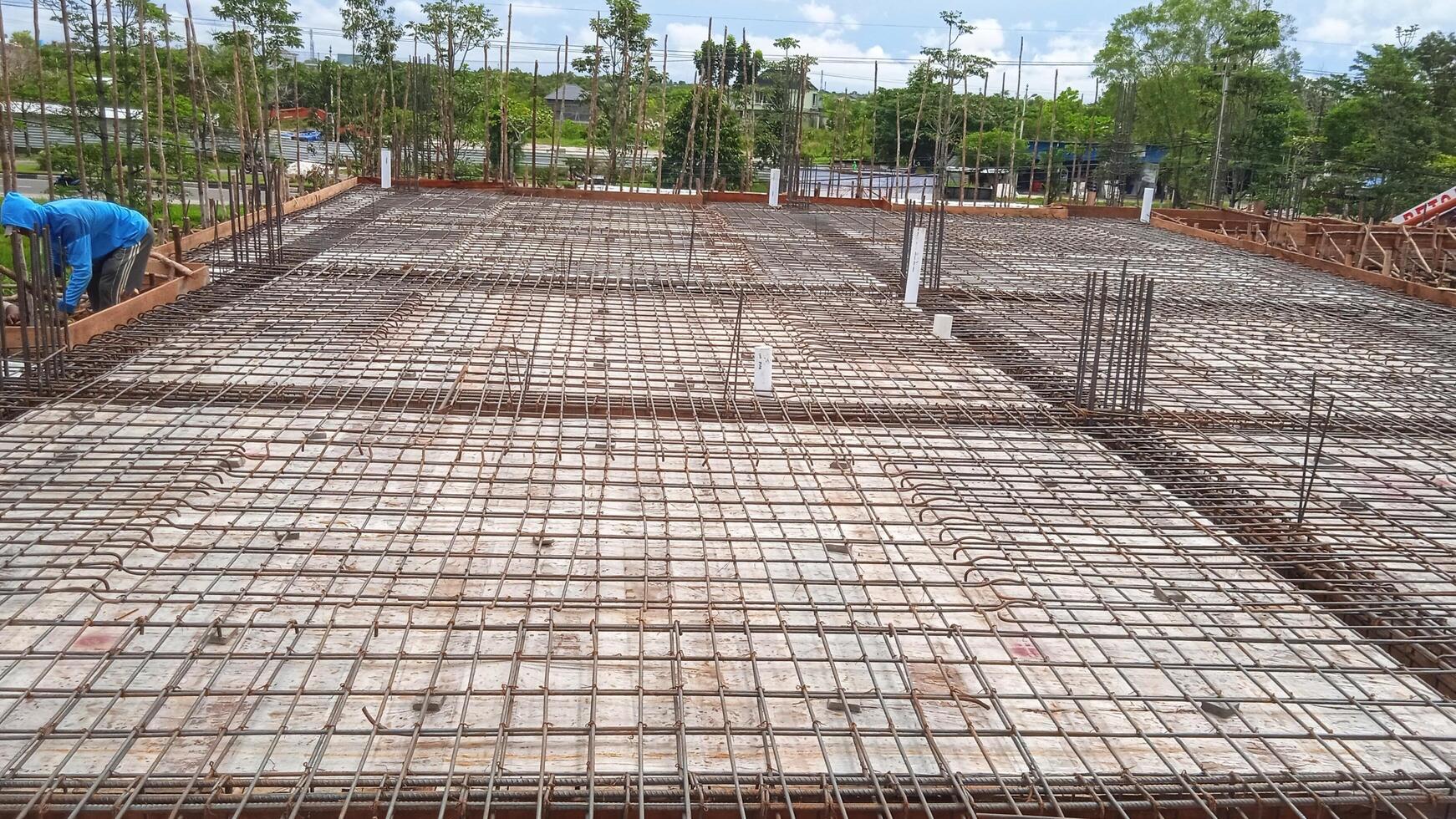Construction worker pours concrete on the concrete floor of a building at a construction site photo