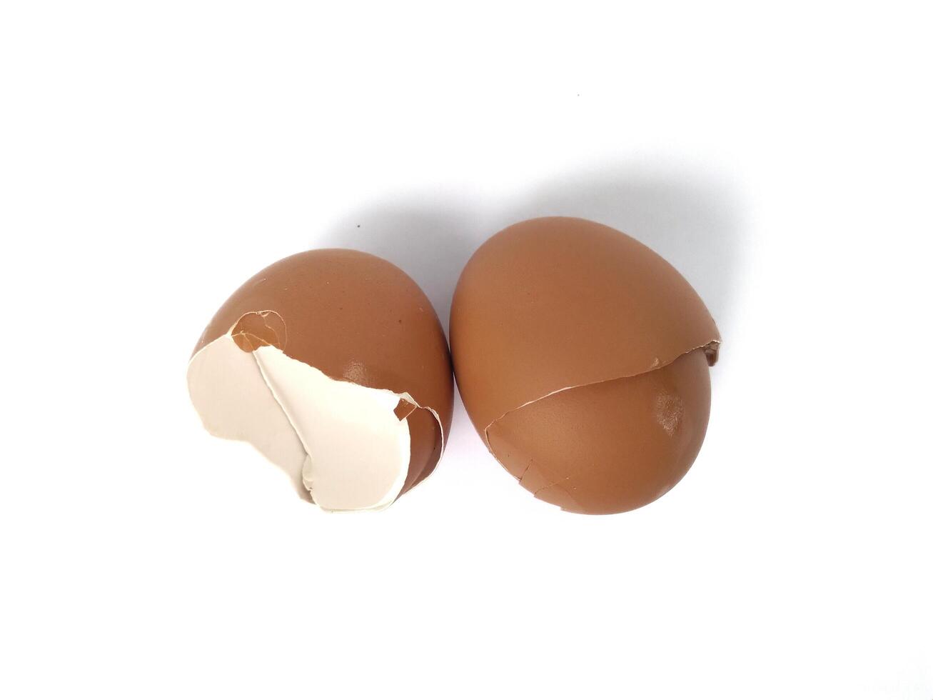 brown egg shell broken or crack with pieces scattered on the surface, isolated on white background, cut out photo