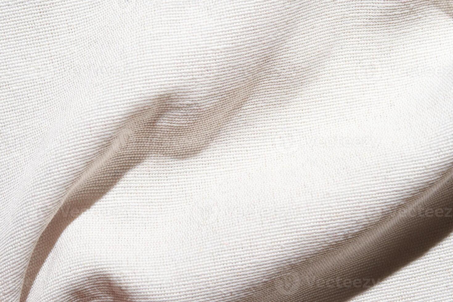 A soft, pure white fabric background with a delicate grid pattern. The texture is smooth and plain, resembling linen or cotton. Light creates subtle shadows on the surface. photo