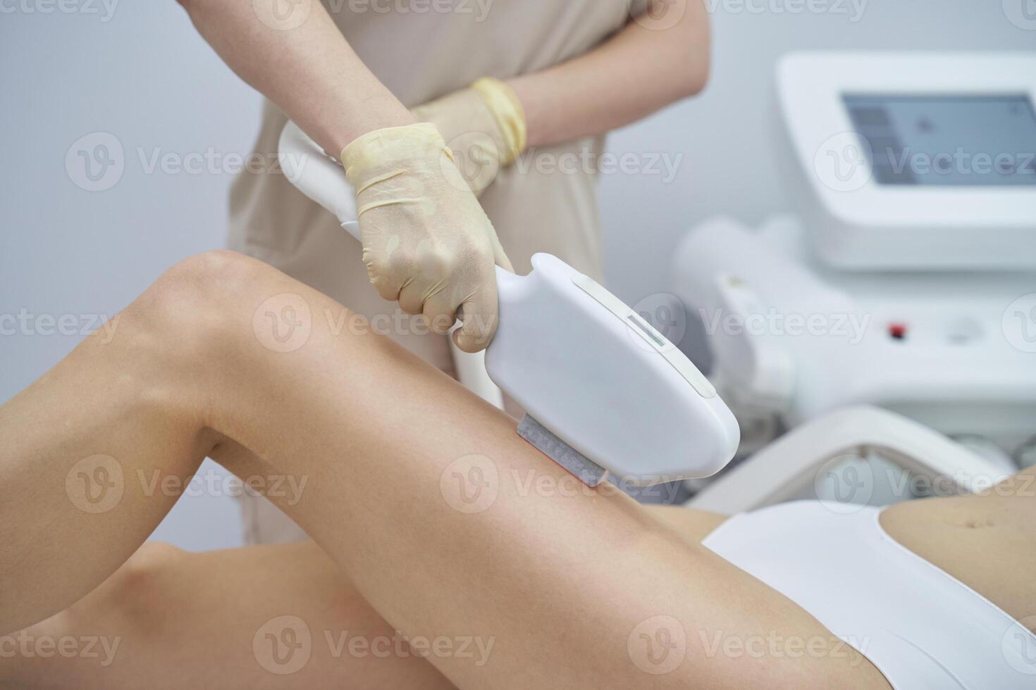 A professional beauty spa offers laser hair removal. A woman undergoes the painless treatment, enhancing smooth, healthy skin. The device is held by a skilled therapist's hand for effective epilation photo