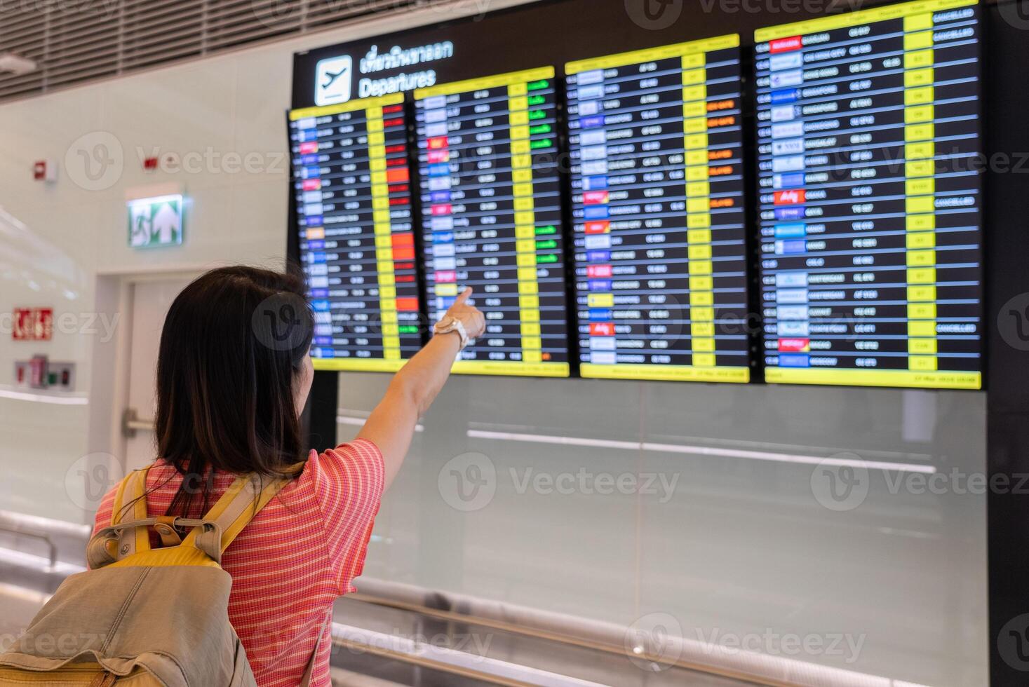 Passenger Looking at Flight Schedule in Terminal Area of Airport photo