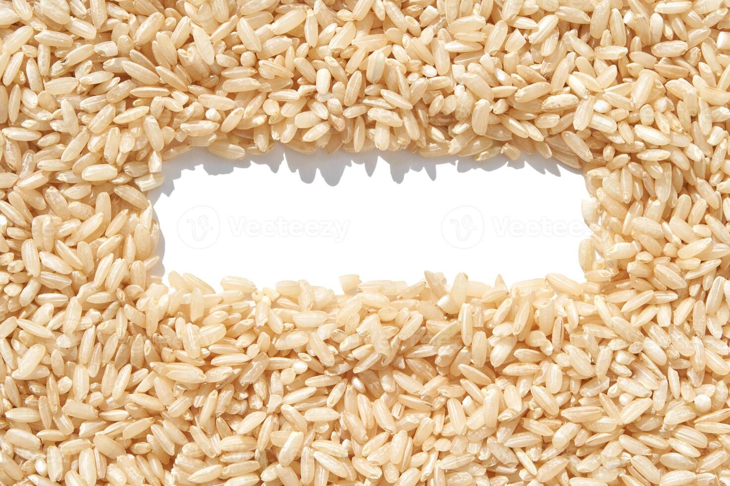 A rectangle frame captures a heap of brown basmati rice on a white background. The texture of long grains symbolizes nutrition and healthy cuisine, addressing hunger and poverty photo