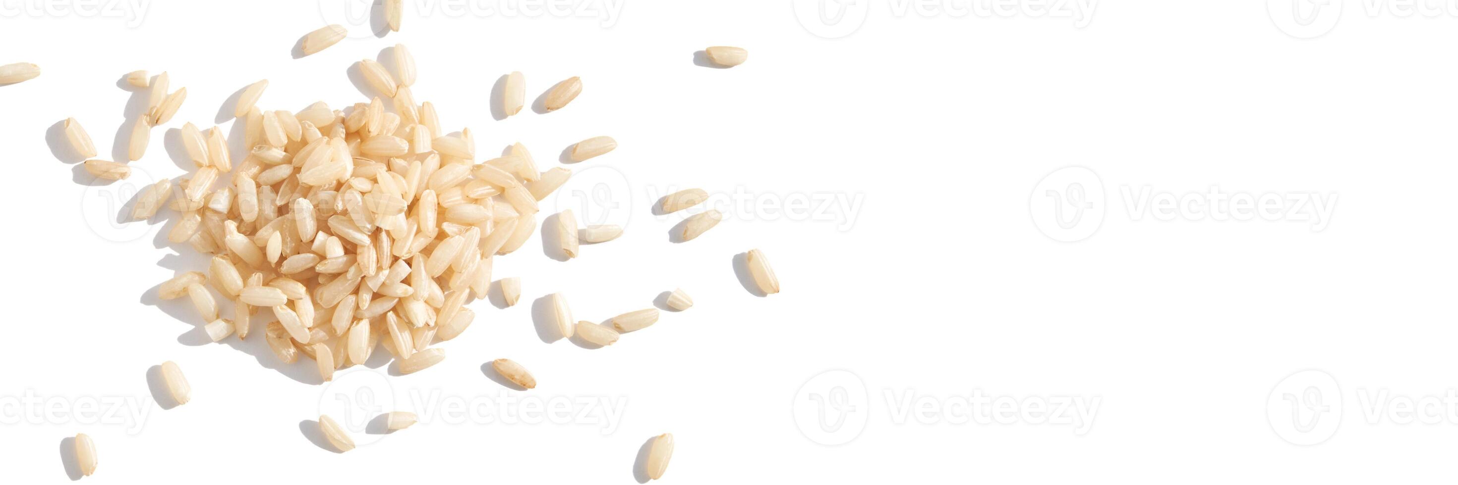 A top view of raw brown and white rice, forming a heap. The integral, uncooked grains highlight diverse Asian cuisine in this isolated pile. Horizontal banner photo