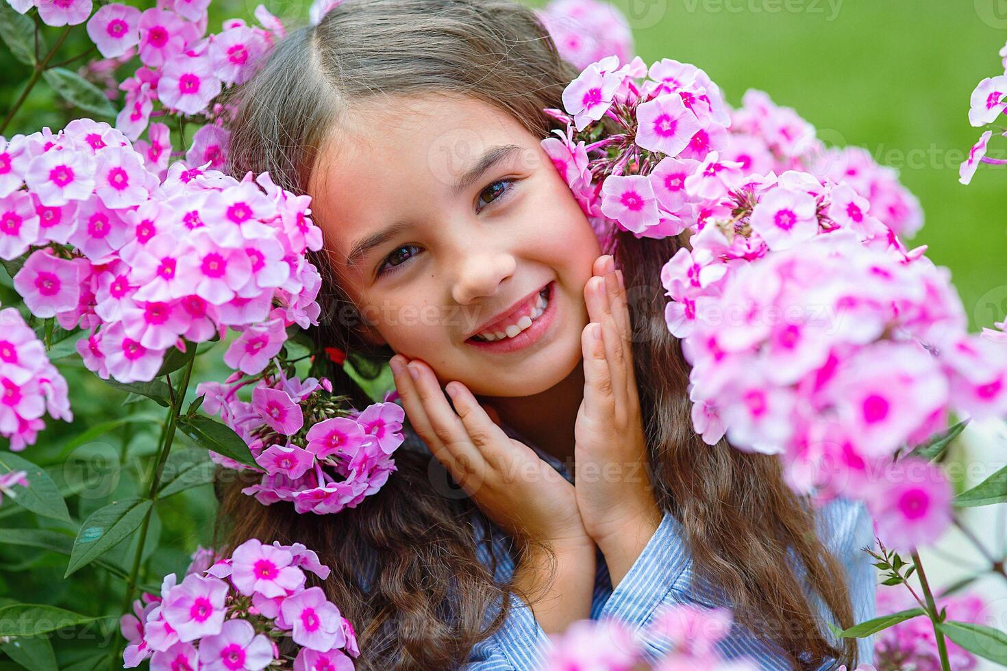Adorable little girl in pink flowers phlox photo