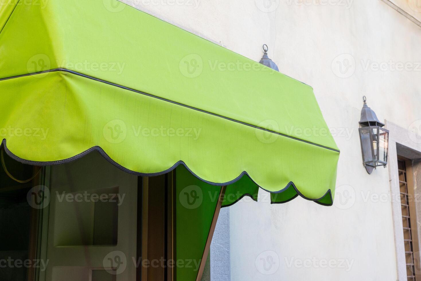 Green awning in front of a shop window. Blank space for printing logo or text. Perfect for storefront advertising and branding opportunities photo