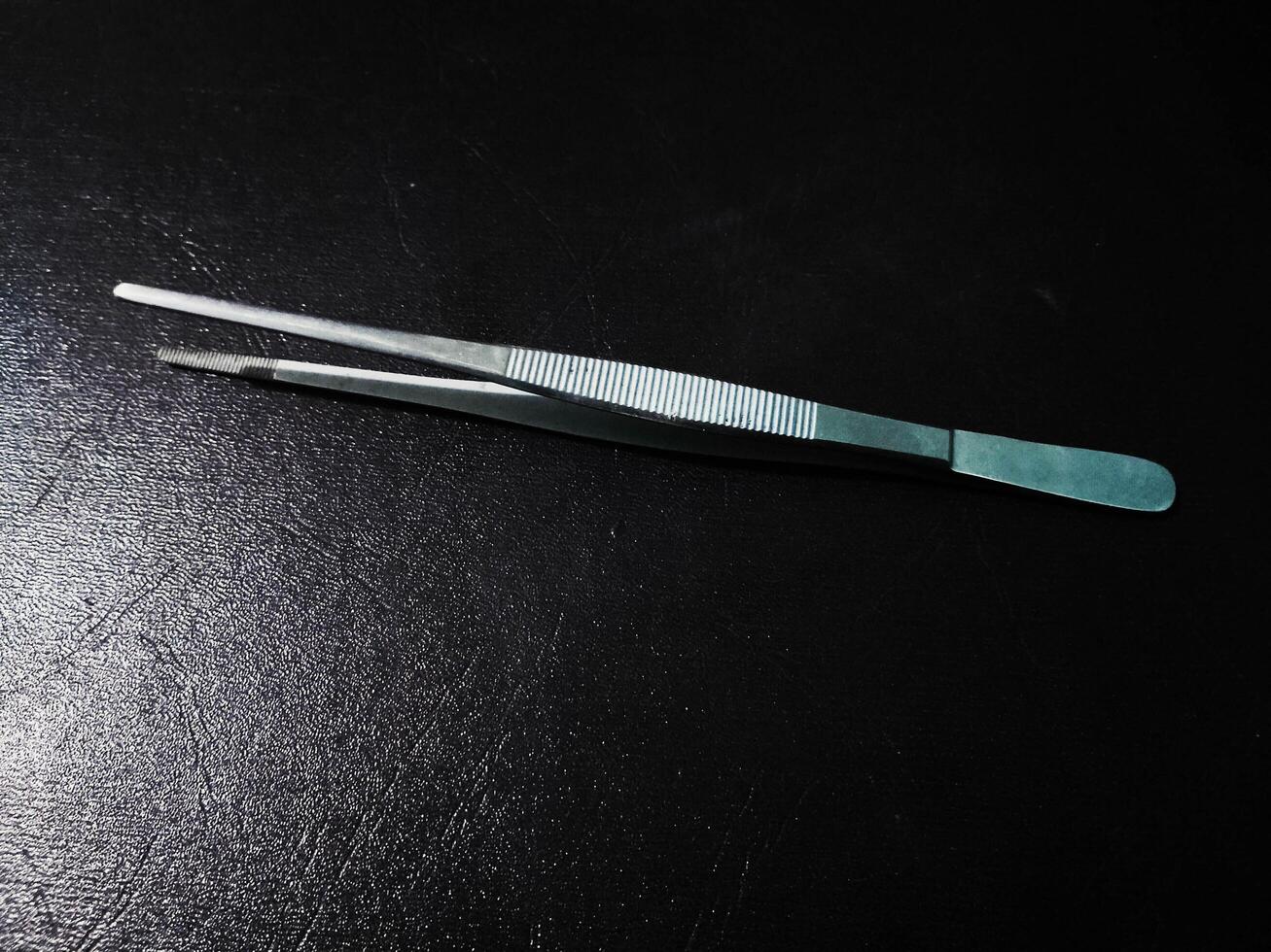 surgical instrument stainless steel smooth forceps isolated on Black Background photo