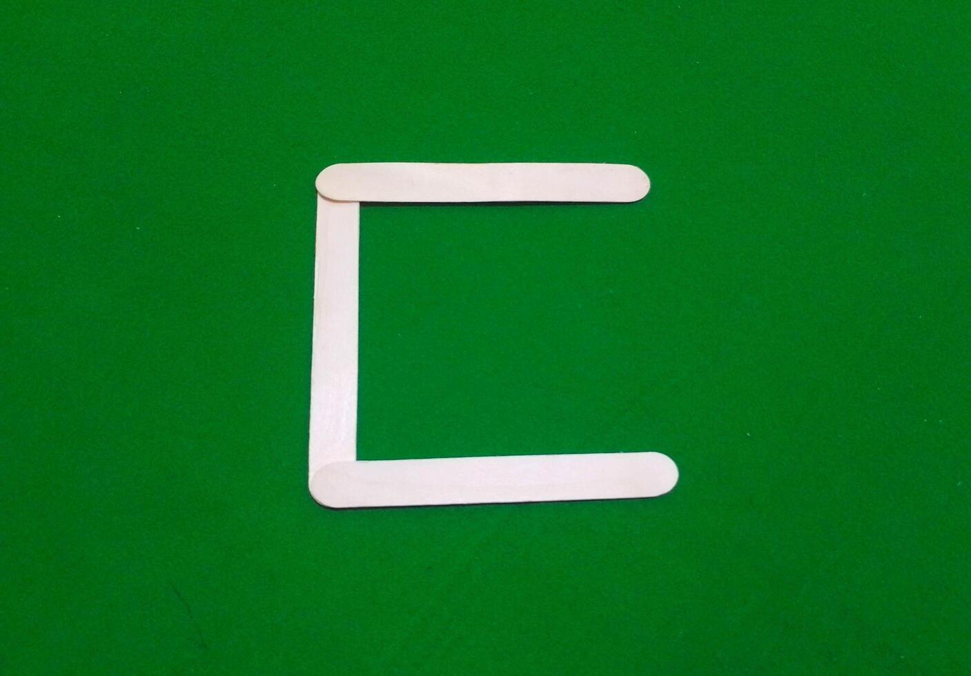 Letter C with Wooden Ice Cream Stick isolated on green chroma background photo