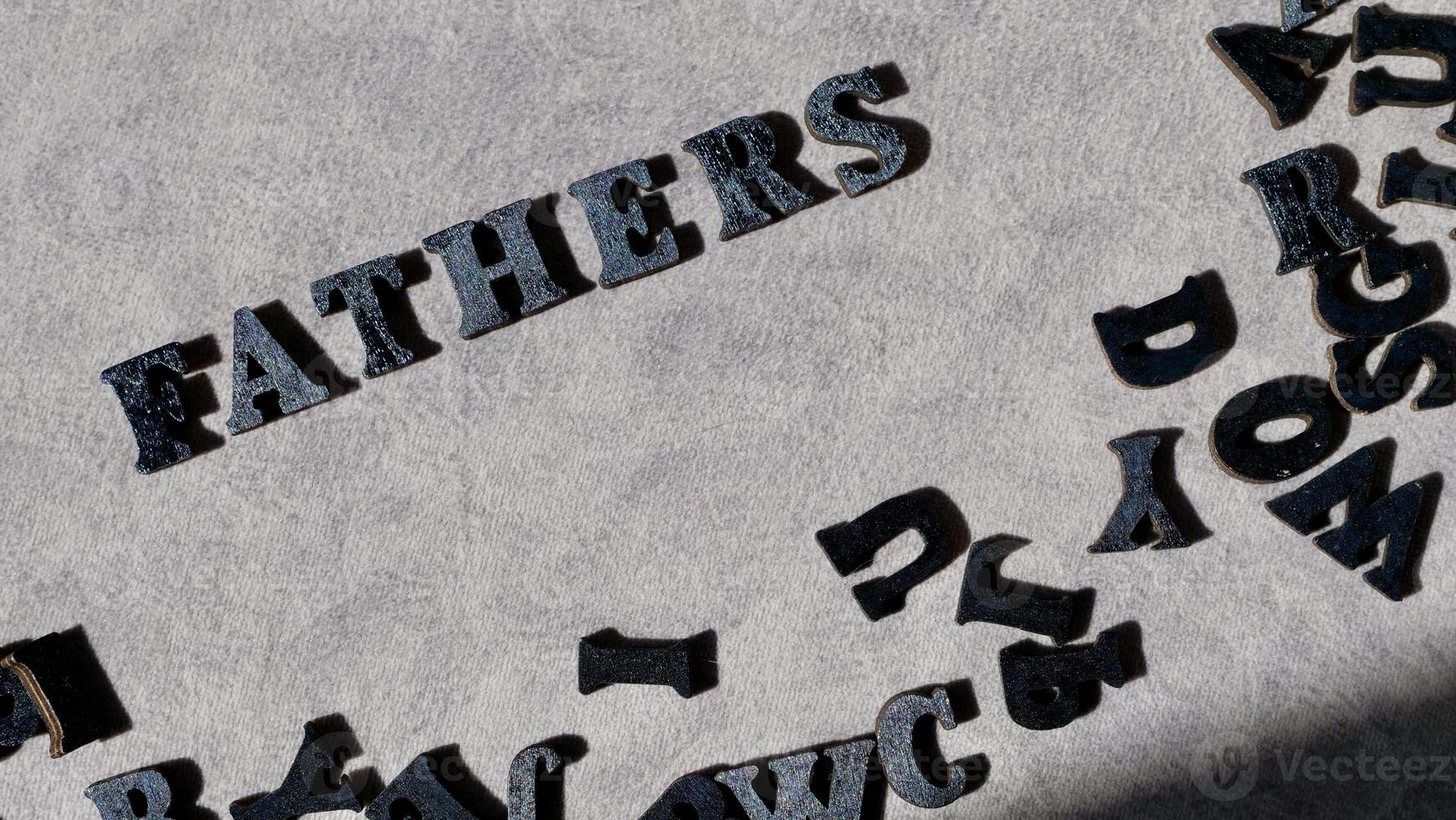 Lettering father in black letters on grey background on father's day close-up photo