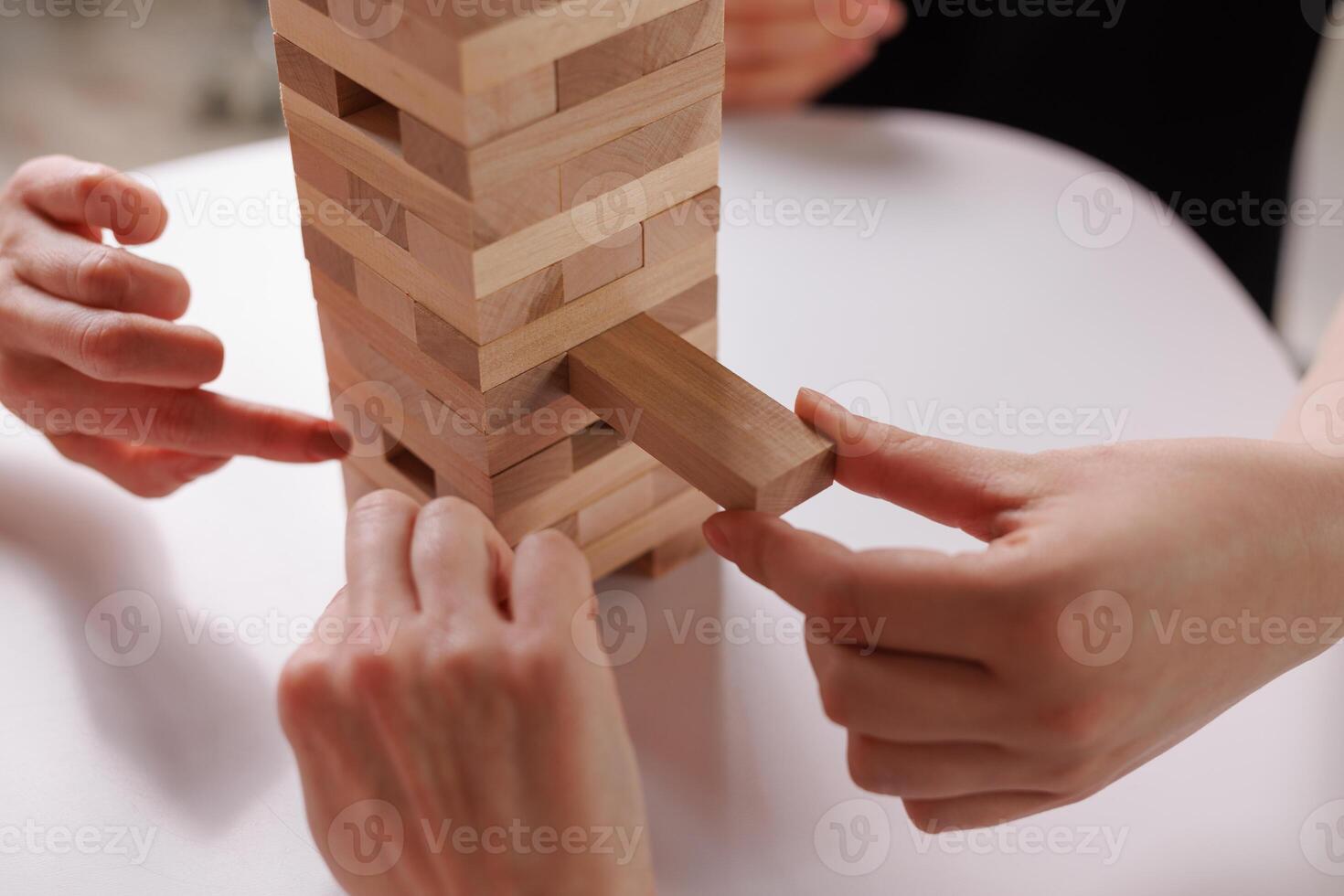 two women playing a board game made of wooden blocks at home, excitement and relaxation, mind development concept, hand motor skills, photo