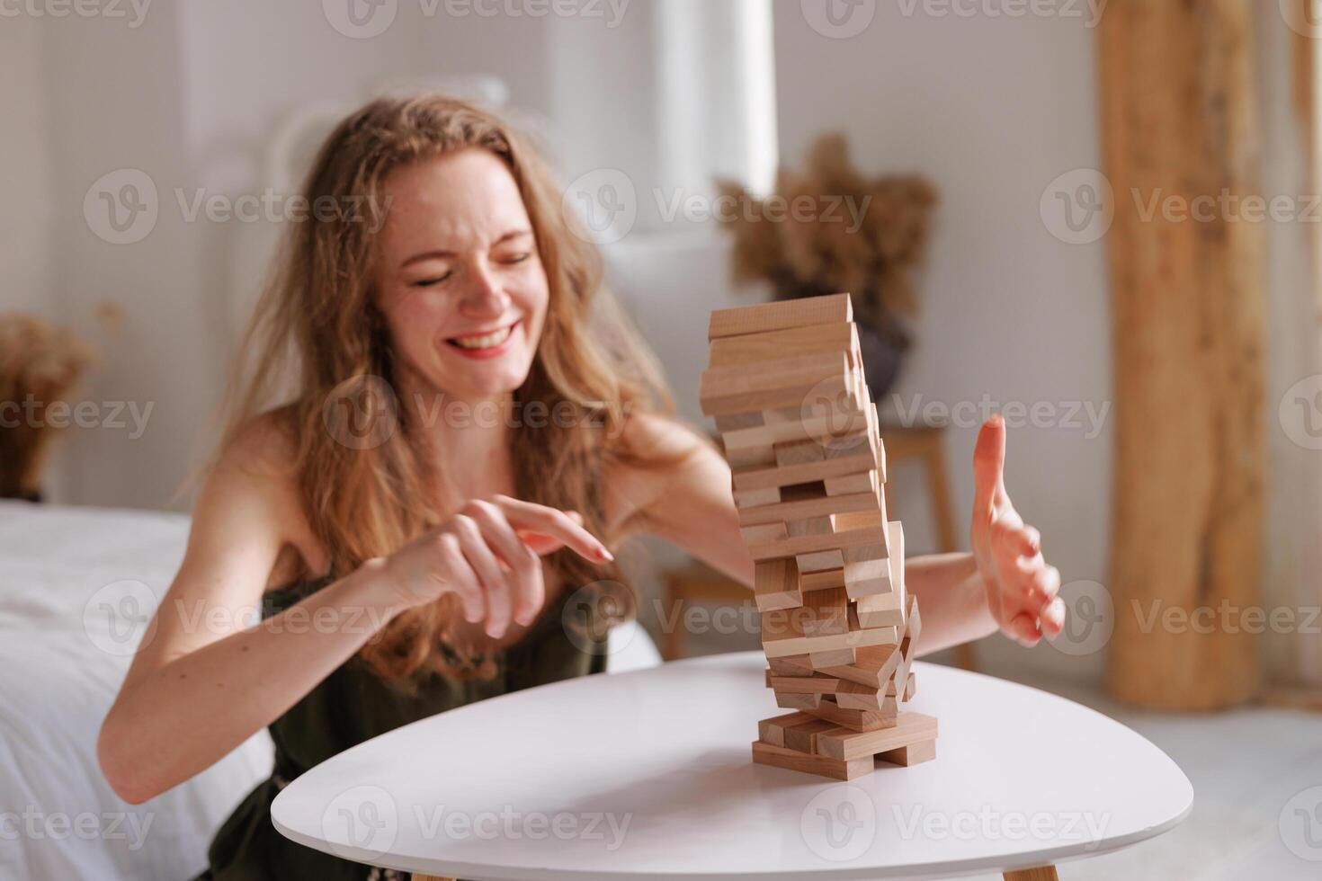 two women playing a board game made of wooden blocks at home, excitement and relaxation, mind development concept, hand motor skills, photo