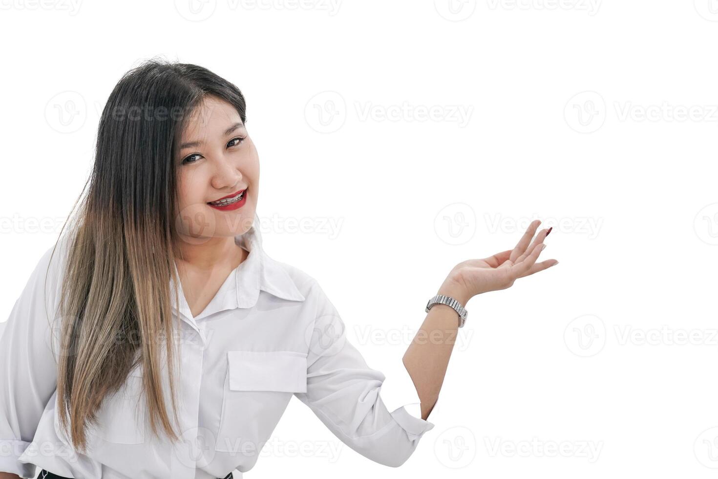 A young Asian woman with a joyful expression raises her left hand in the air and can use it to present or promote products. photo