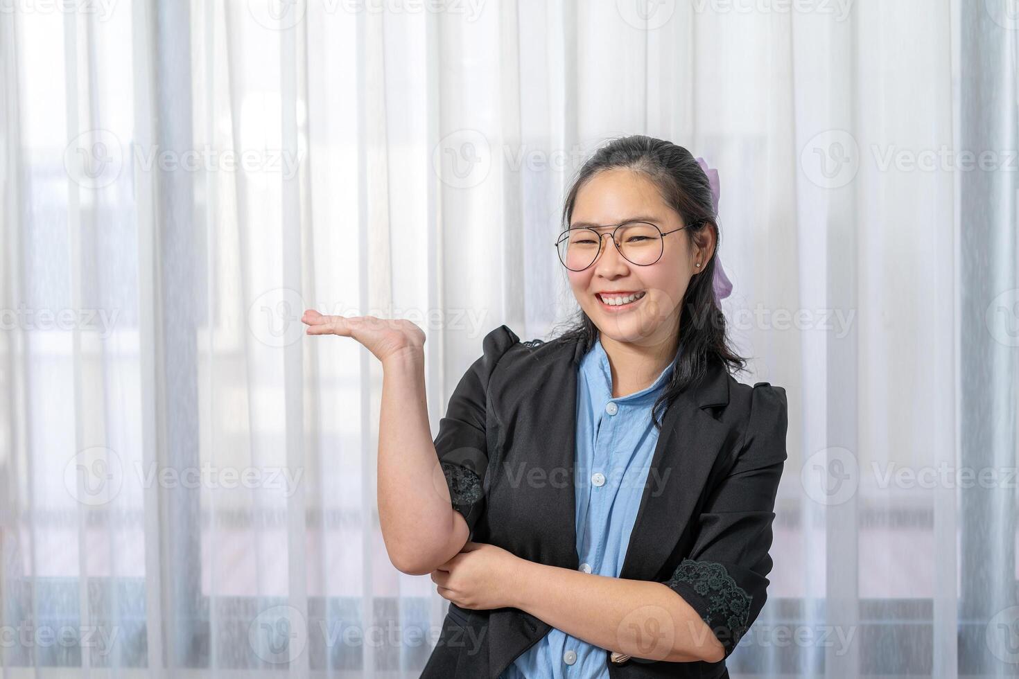 Asian happy woman opens hands palm up showing and holding empty or something with confidential on black copy space for production and information. photo