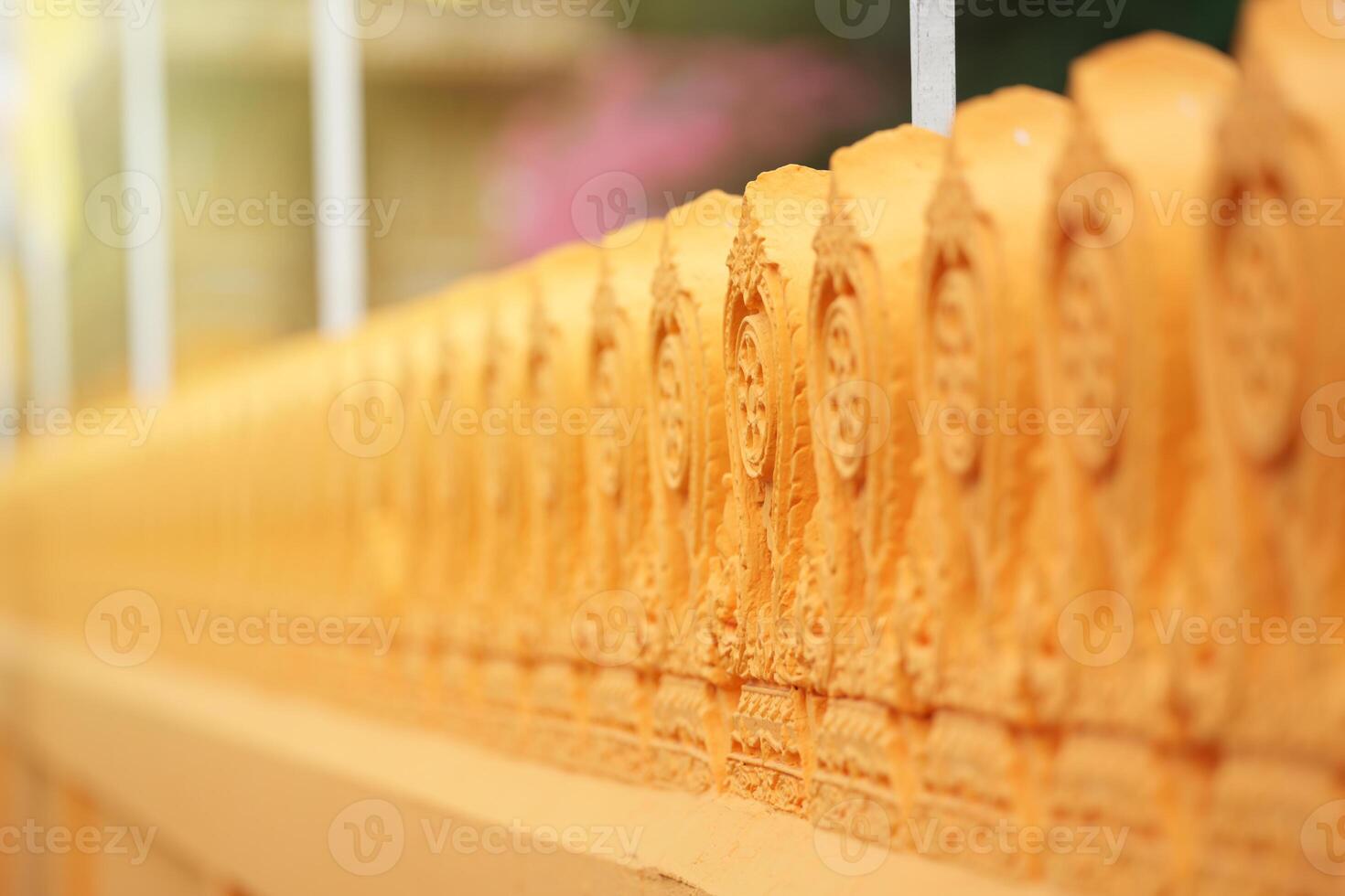 Buddhist temple wall in Orange Yellow color have pattern with beautifully carved and refined. photo