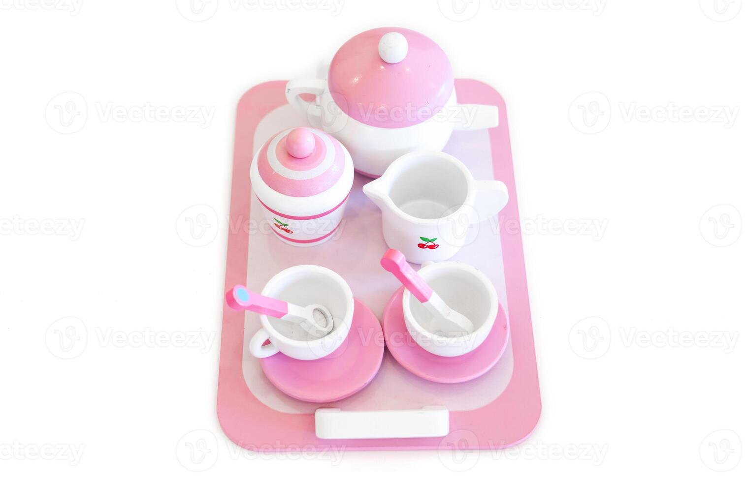 A set of pink white pastel color wood toy tea cups including 2 coffee cups with teaspoons, a teapot, a sugar jar and a milk jug is placed on a tray. Isolate clear on white background. photo