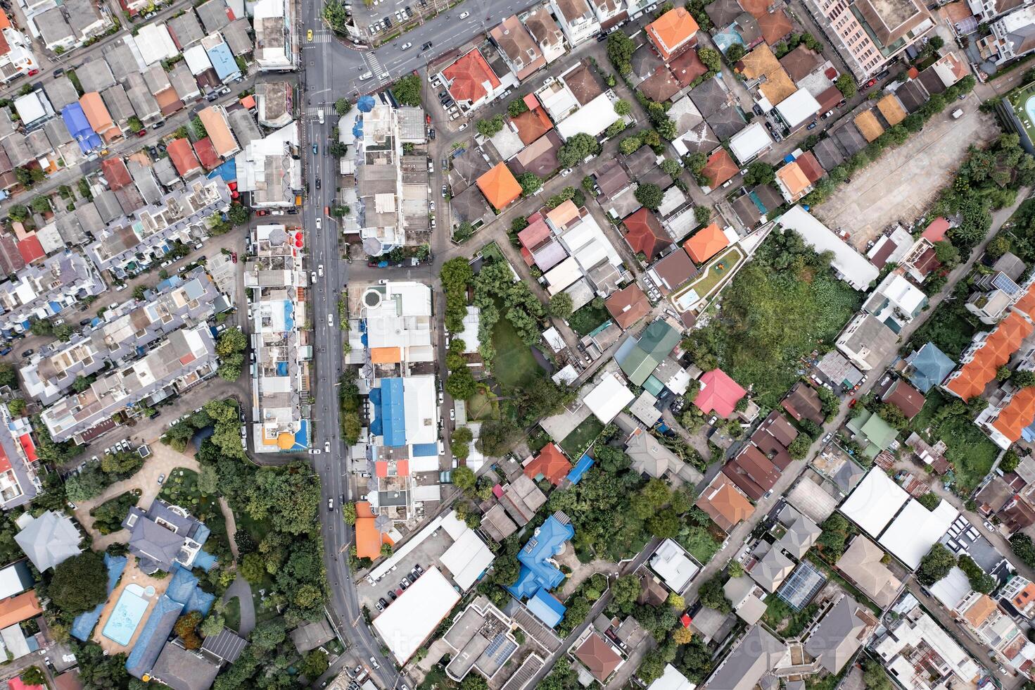 Aerial view of a large city There are many houses arranged in proportions which have a road cut through and a little green area. photo