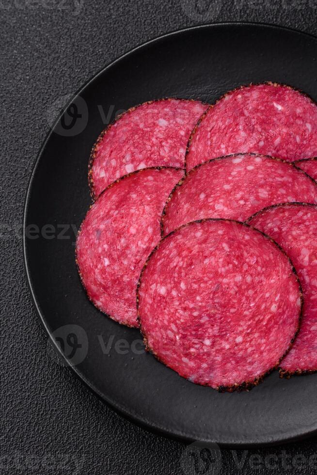 Delicious smoked salami sausage sliced with salt, spices and herbs photo