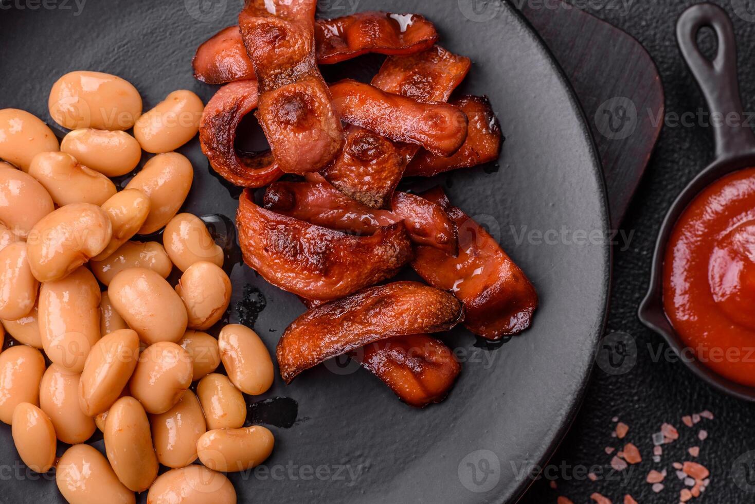 Fried sausages sliced with salt and spices as an ingredient for an English breakfast photo