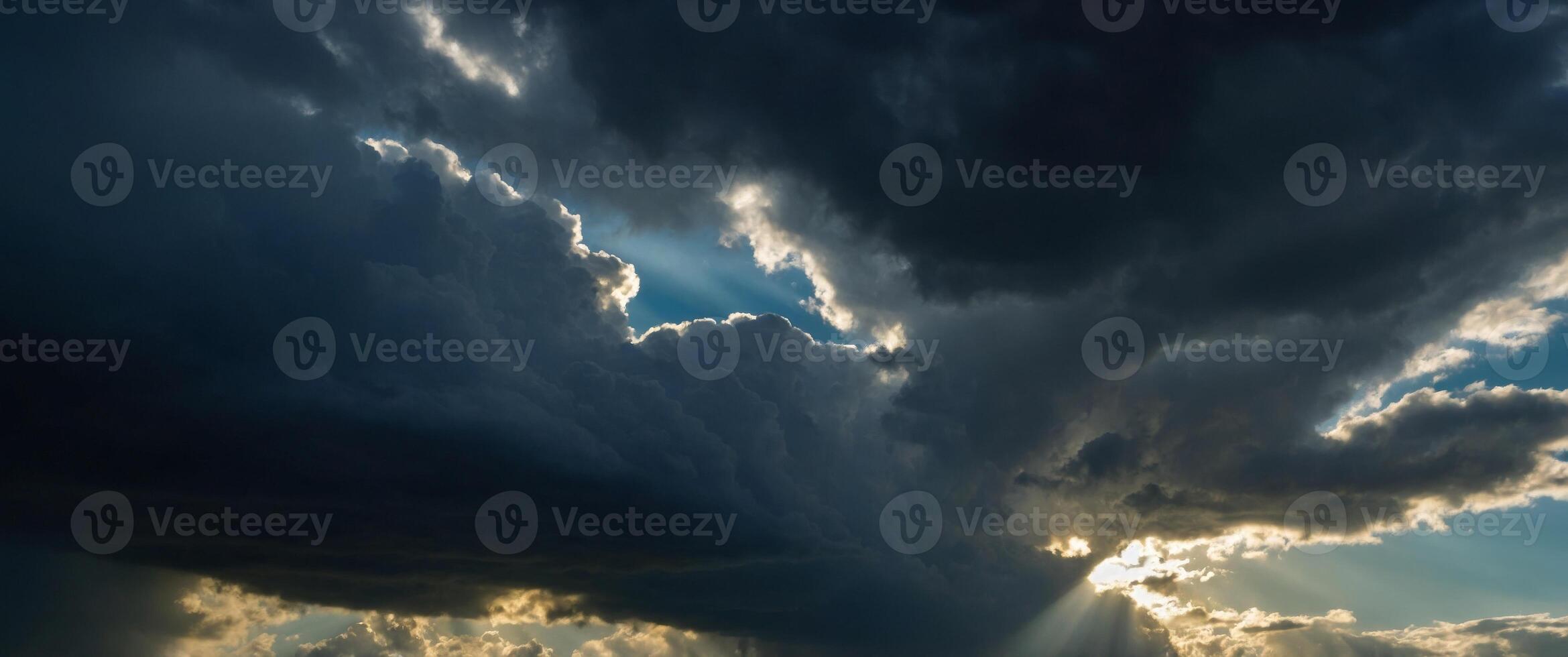 Dramatic sky with rays of light piercing through dark clouds evoking a sense of awe and the sublime beauty of nature. photo