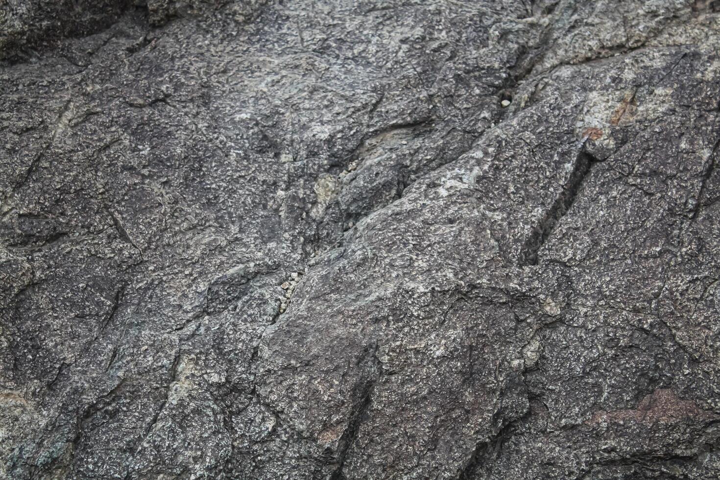 Rough, grey, dark harsh and high contrast granite stone texture background. A close-up of the surface of abstract natural rock. Natural Marble stone wallpaper. photo