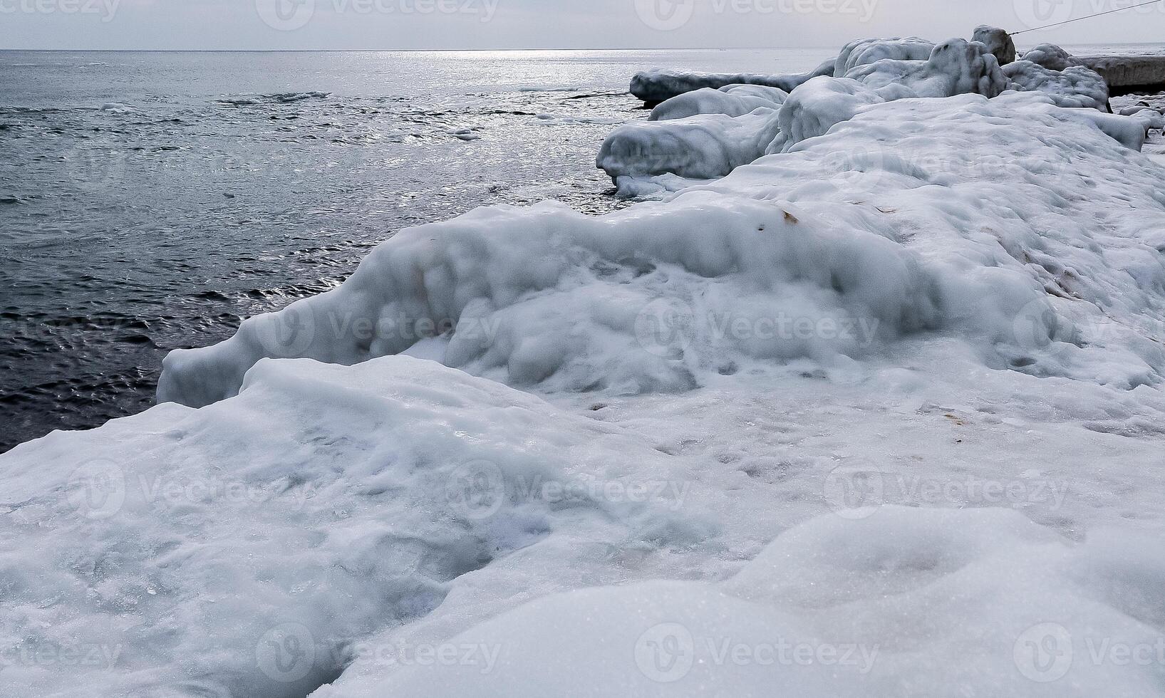 Ice-covered shore, rocks and coastal cliffs. The Black Sea is frozen photo