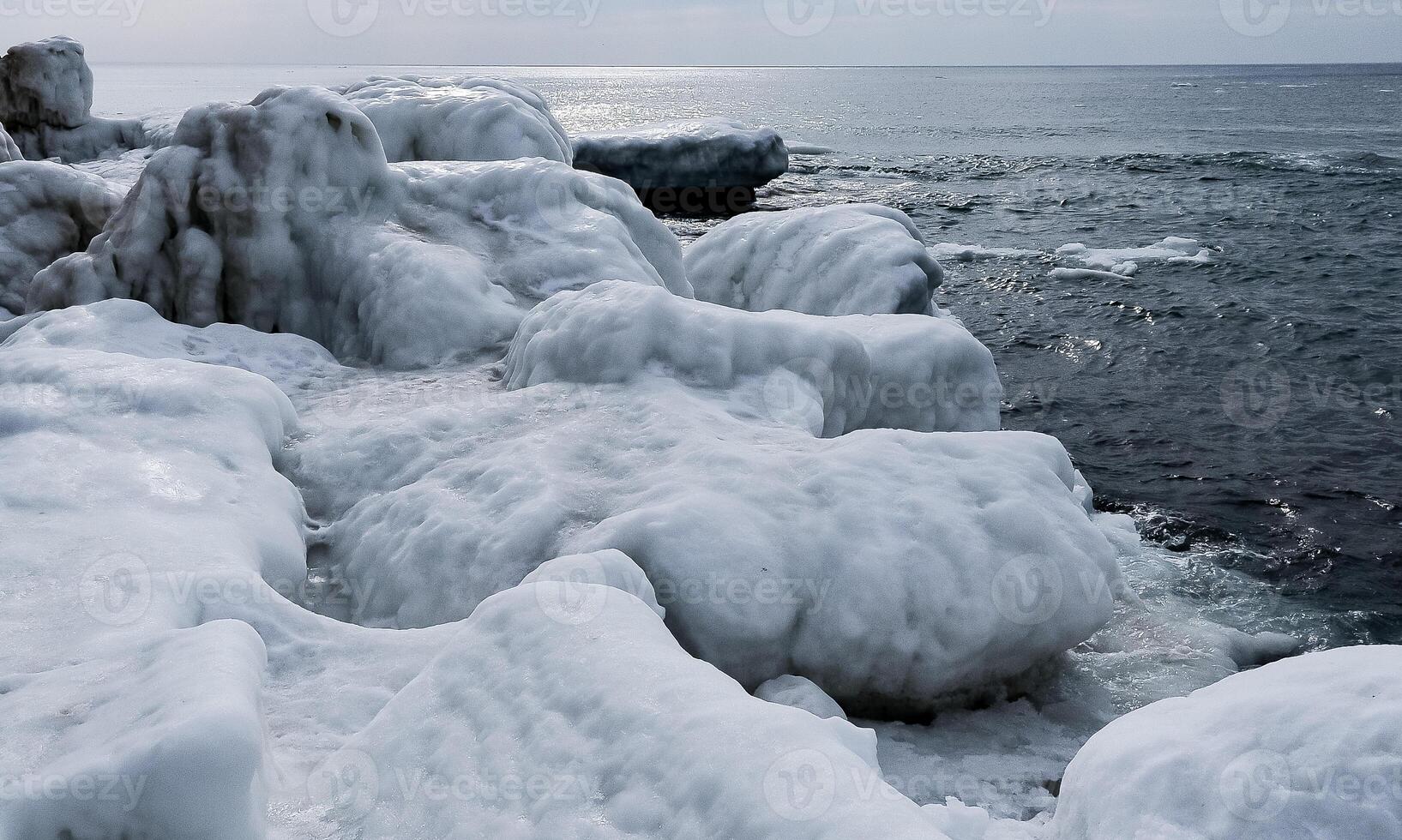 Ice-covered shore, rocks and coastal cliffs. The Black Sea is frozen photo