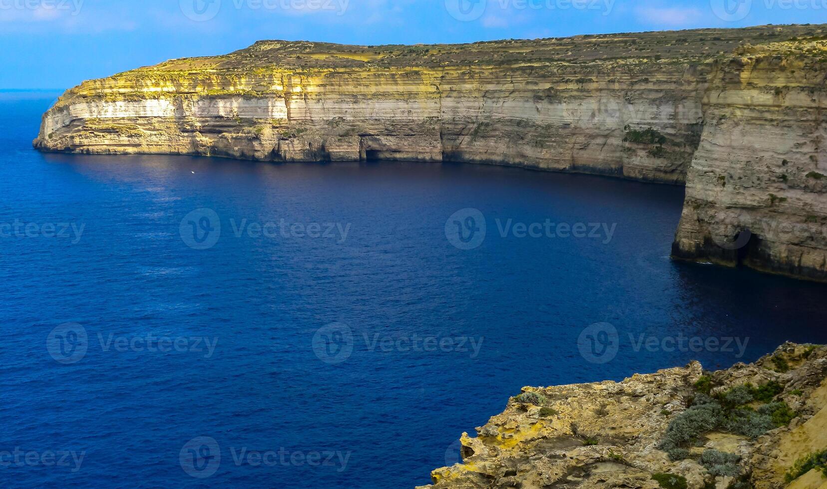 High vertical rocky shore on the island of Gozo, Malta photo
