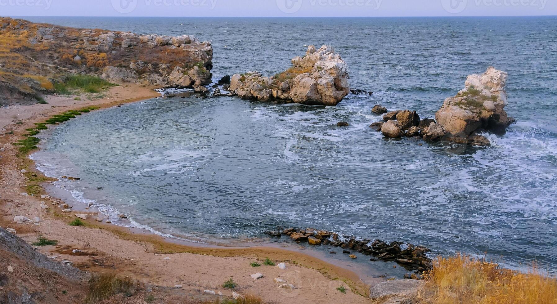 A small cozy sandy cove among the coastal rocks in the eastern Crimea, Kazantip, the Black Sea photo