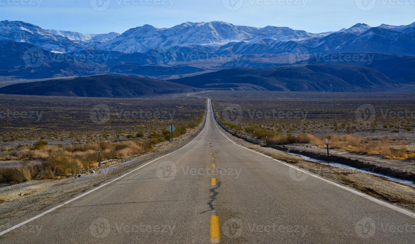 Straight Road in the California desert, going into the mountains near Death Valley National Park photo