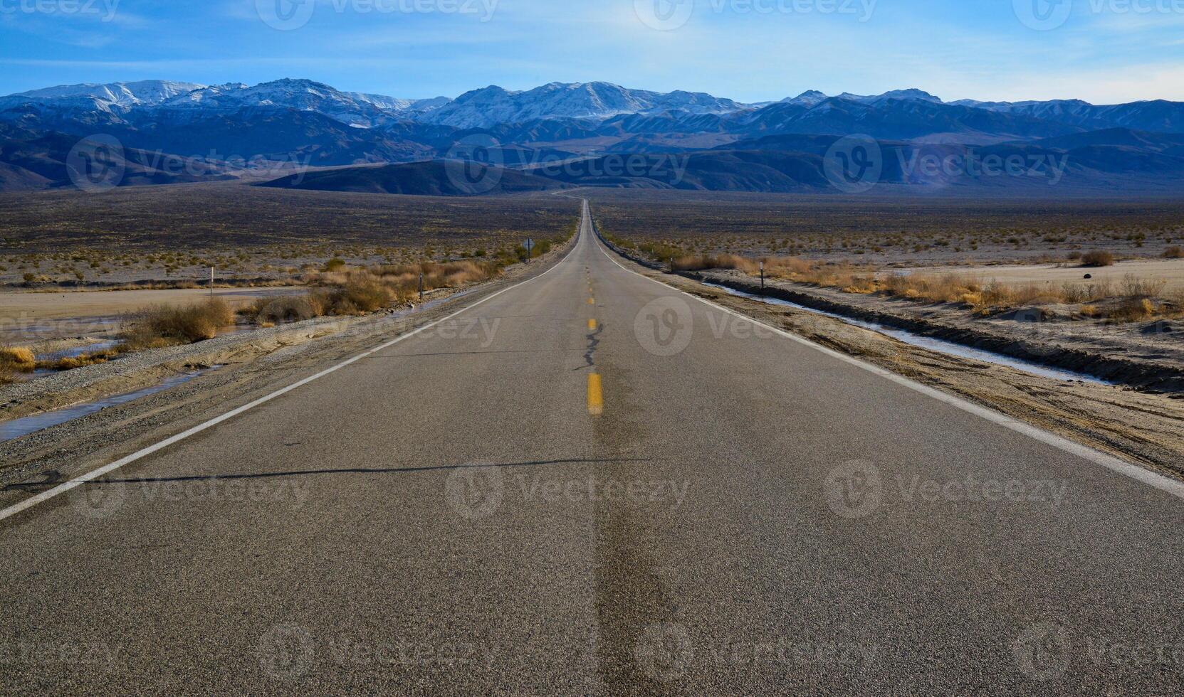 Straight Road in the California desert, going into the mountains near Death Valley National Park photo
