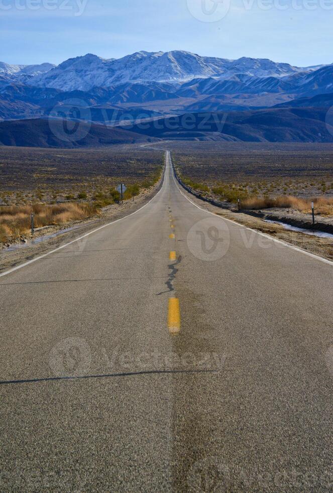 Straight Road in the California desert, going into the mountains near Death Valley National Park photo
