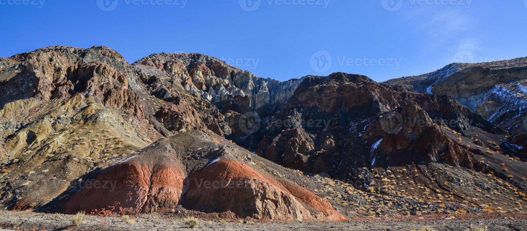 Landscape of a valley overgrown with desert vegetation and cacti in the rock desert in California, mountains in the background photo