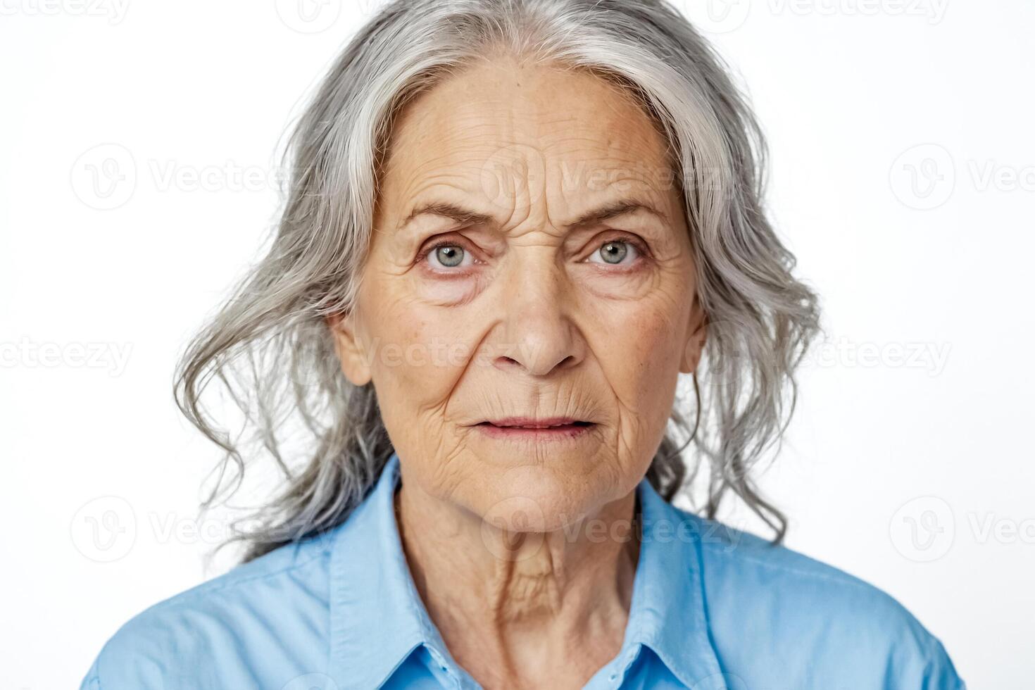Senior Woman with Grey Hair and Blue Shirt Looks at Camera photo