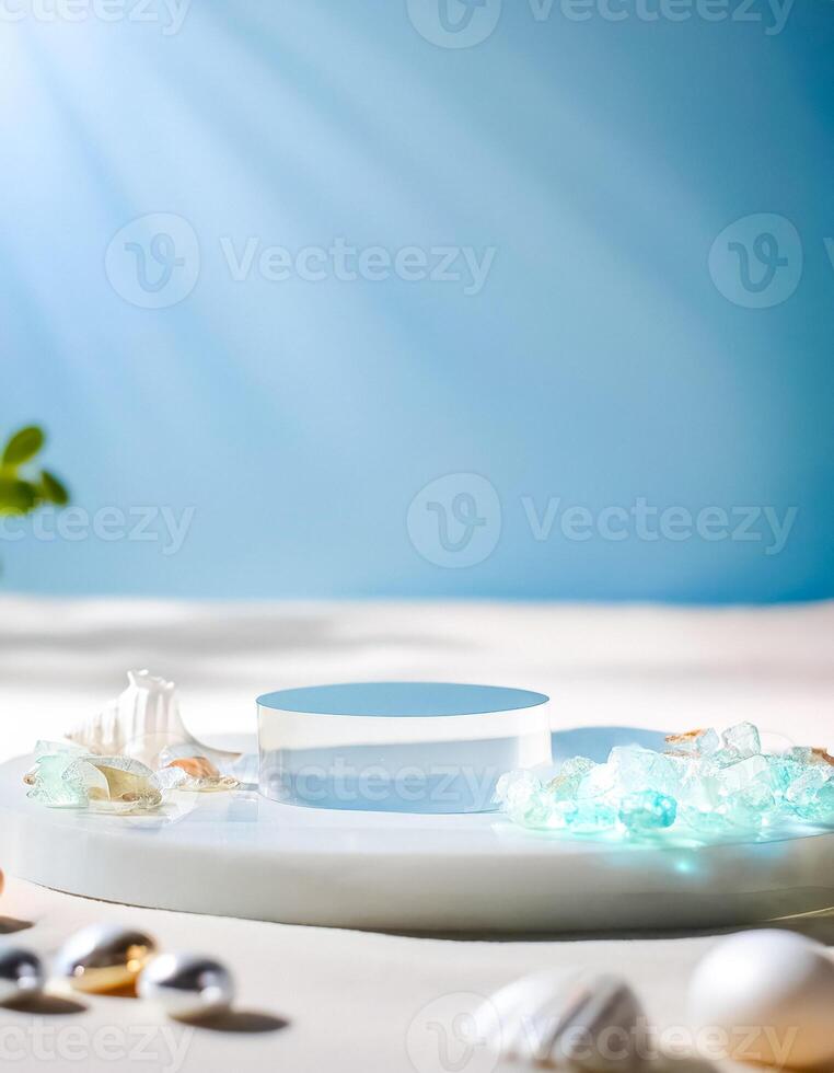 Clear Glass Cylinder Podium with White Marble Platform, Seashells and Sea Glass on White Surface with Blue Background photo