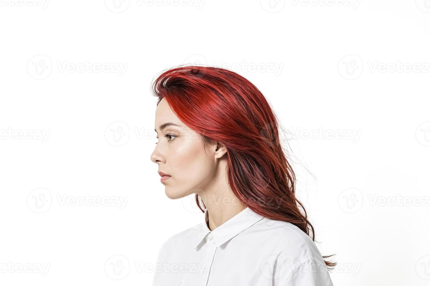 Portrait of a young woman with red hair looking away photo